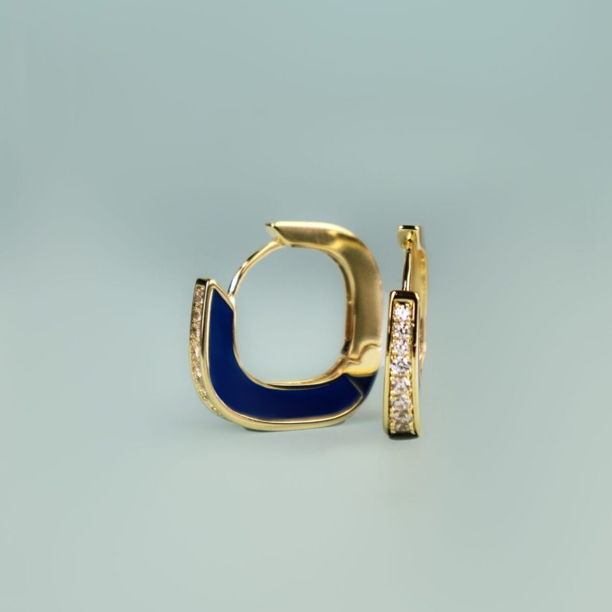 Elegant gold hoop earrings featuring blue enamel and sparkling diamonds, showcasing modern jewelry design.