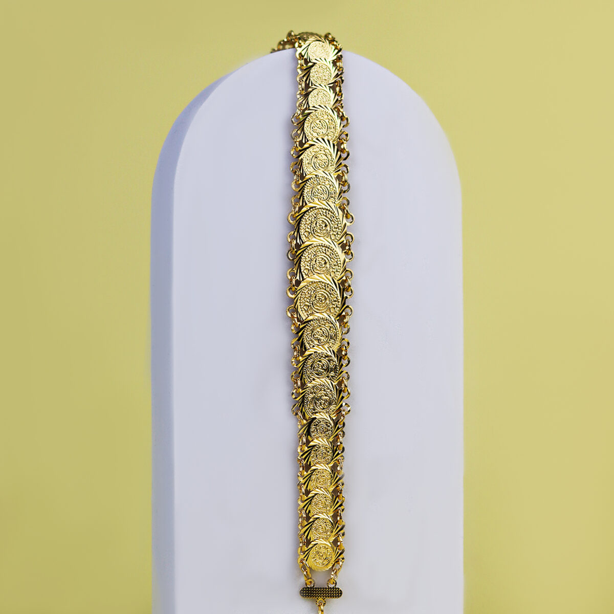 Gold bracelet featuring a series of coin-shaped designs linked together.