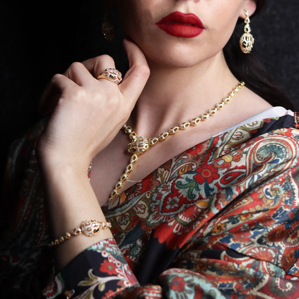 Model showcasing an elegant gold jewelry set including earrings, necklace, bracelet, and ring, highlighting intricate designs and craftsmanship.