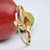 Gold bangle featuring butterfly accents and crystal embellishments, showcasing elegance and style.