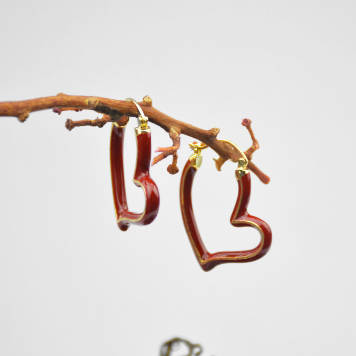Stylish heart-shaped red earrings with gold accents, perfect for adding a touch of elegance to any outfit. Lightweight and trendy design.